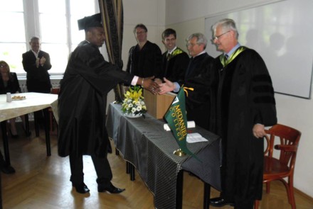 Idamina Babarinsa receiving his diploma, shaking hands with Dr. Gábor Drexler 